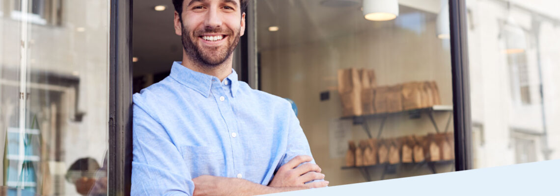 A man standing in front of a counter with his arms crossed.